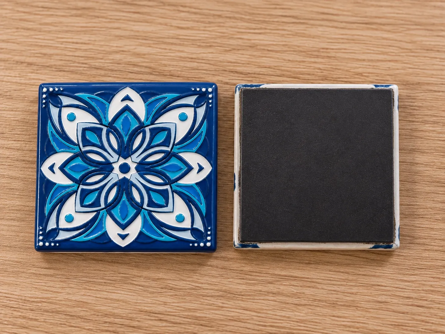 Two square magnets side by side: one showing a blue floral design, the other its black magnetic back.