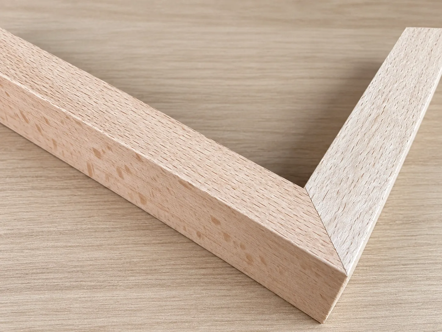 Close view of a natural wood frame corner with a tight mitre joint.