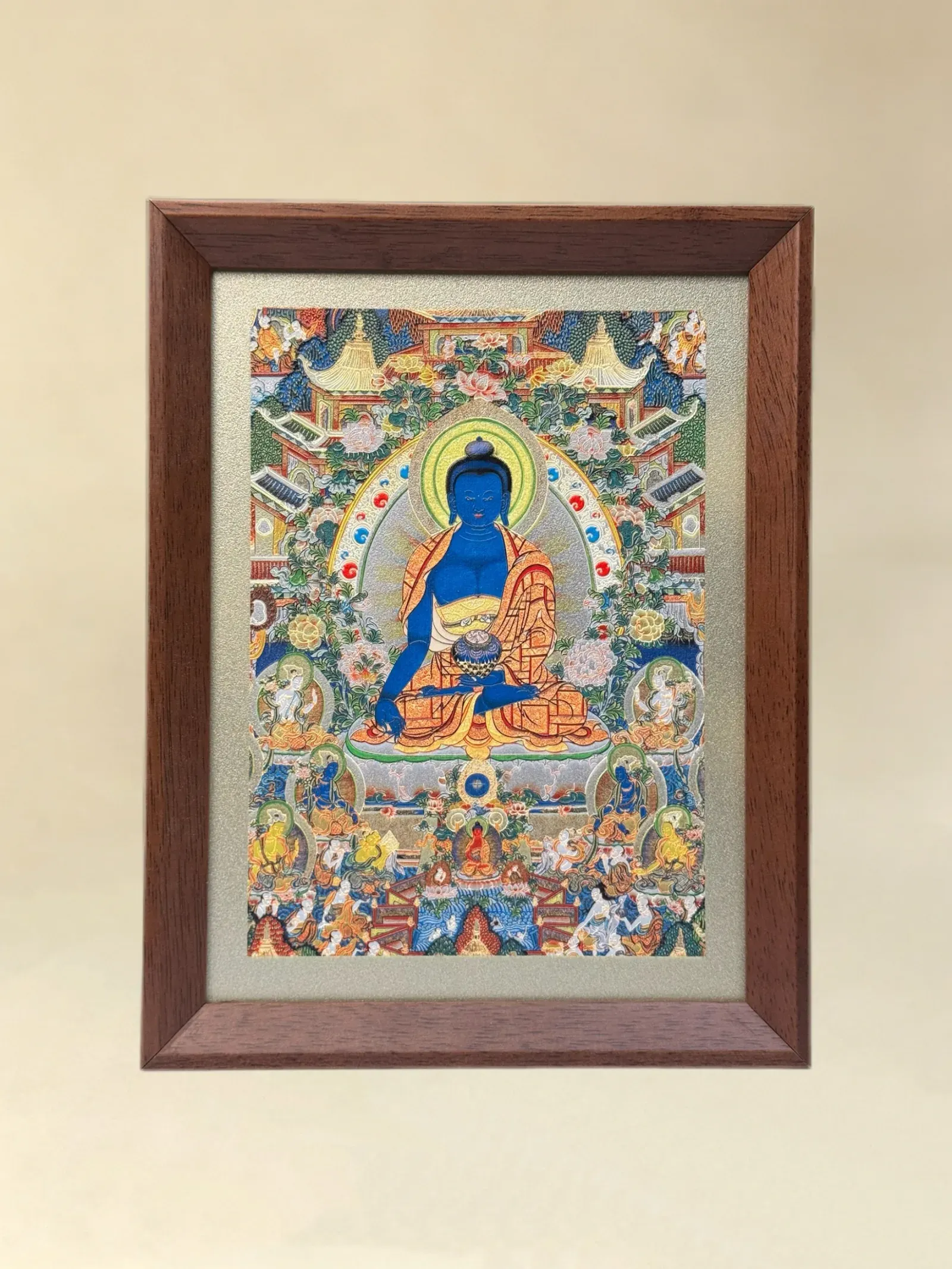 A relief artwork of Medicine Buddha, as a desktop frame, photographed front on.