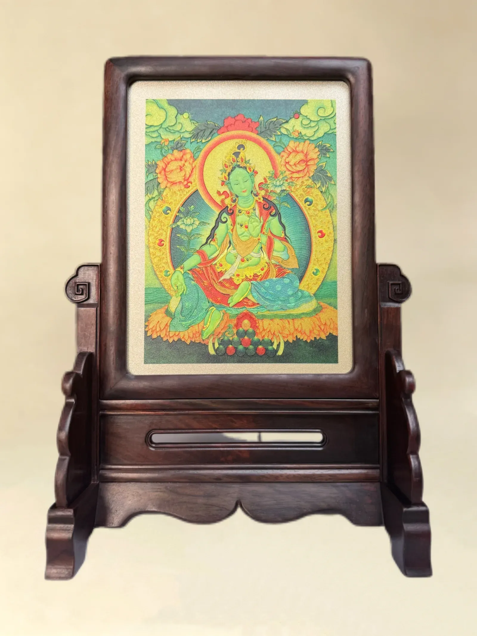 A relief artwork of Green Tara, golden halo, as a table screen, photographed front on.