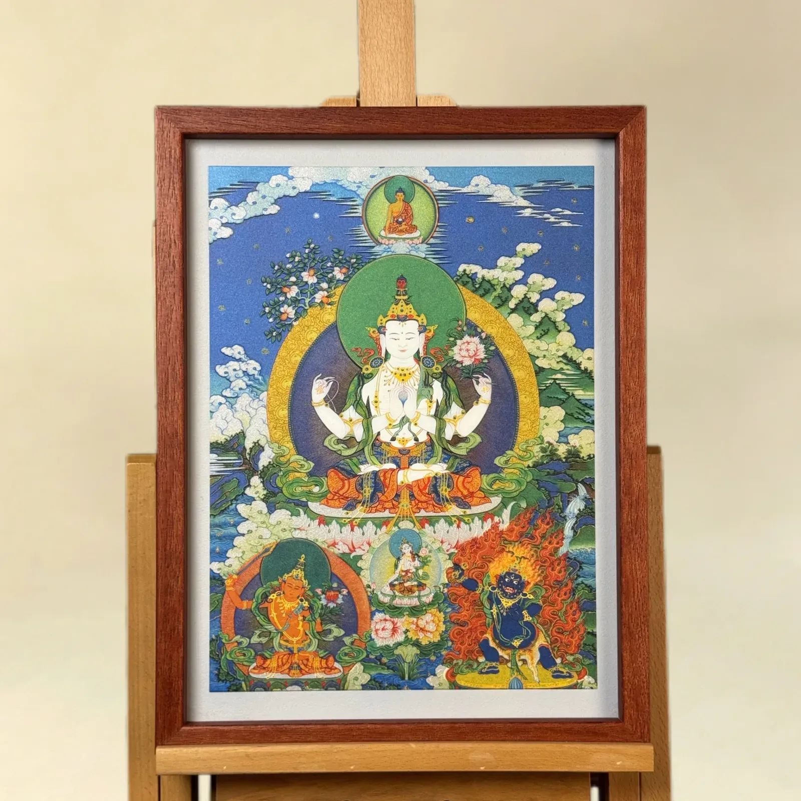 The same Four-Armed Avalokiteshvara relief artwork as a larger framed wall piece on an easel.